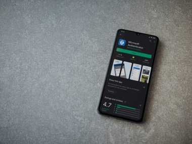 Lod, Israel - 8 Temmuz 2020: Microsoft Authenticator uygulama oyun mağazası sayfası seramik taş zemin üzerinde siyah bir cep telefonu görüntüsü. Üst görünüm düzlüğü kopyalama alanı ile yatıyordu.