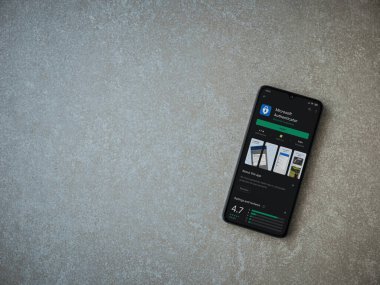 Lod, Israel - 8 Temmuz 2020: Microsoft Authenticator uygulama oyun mağazası sayfası seramik taş zemin üzerinde siyah bir cep telefonu görüntüsü. Üst görünüm düzlüğü kopyalama alanı ile yatıyordu.