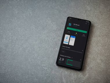 Lod, Israel - 8 Temmuz 2020: Mi Mover uygulama oyun mağazası sayfası seramik taş zemin üzerinde siyah bir cep telefonu ekranında. Üst görünüm düzlüğü kopyalama alanı ile yatıyordu.