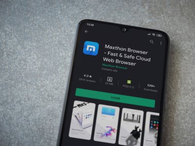 Lod, Israel - 8 Temmuz 2020: Maxthon Tarayıcı uygulama oyun mağazası sayfası seramik taş zemin üzerinde siyah bir cep telefonu görüntüsü. Üst görünüm düzlüğü kopyalama alanı ile yatıyordu.