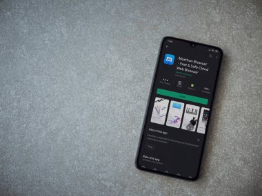 Lod, Israel - 8 Temmuz 2020: Maxthon Tarayıcı uygulama oyun mağazası sayfası seramik taş zemin üzerinde siyah bir cep telefonu görüntüsü. Üst görünüm düzlüğü kopyalama alanı ile yatıyordu.