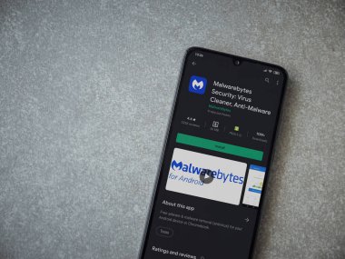 Lod, Israel - 8 Temmuz 2020: Malwarebytes Security uygulama oyun mağazası sayfası seramik taş zemin üzerinde siyah bir cep telefonu görüntüsü. Üst görünüm düzlüğü kopyalama alanı ile yatıyordu.