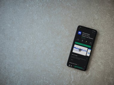 Lod, Israel - 8 Temmuz 2020: Malwarebytes Security uygulama oyun mağazası sayfası seramik taş zemin üzerinde siyah bir cep telefonu görüntüsü. Üst görünüm düzlüğü kopyalama alanı ile yatıyordu.