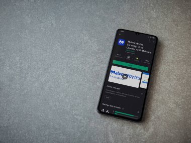 Lod, Israel - 8 Temmuz 2020: Malwarebytes Security uygulama oyun mağazası sayfası seramik taş zemin üzerinde siyah bir cep telefonu görüntüsü. Üst görünüm düzlüğü kopyalama alanı ile yatıyordu.
