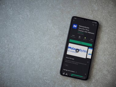 Lod, Israel - 8 Temmuz 2020: Malwarebytes Security uygulama oyun mağazası sayfası seramik taş zemin üzerinde siyah bir cep telefonu görüntüsü. Üst görünüm düzlüğü kopyalama alanı ile yatıyordu.