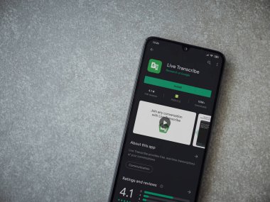 Lod, Israel - 8 Temmuz 2020: Seramik taş zemin üzerinde siyah bir cep telefonunun ekranında Live Transcribe uygulaması oyun mağazası sayfası. Üst görünüm düzlüğü kopyalama alanı ile yatıyordu.