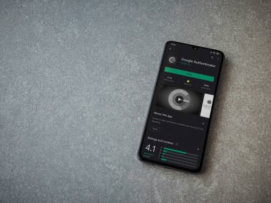 Lod, Israel - 8 Temmuz 2020: Google Authenticator uygulama oyun mağazası sayfası seramik taş zemin üzerinde siyah bir cep telefonu görüntüsü. Üst görünüm düzlüğü kopyalama alanı ile yatıyordu.