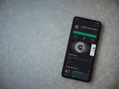 Lod, Israel - 8 Temmuz 2020: Google Authenticator uygulama oyun mağazası sayfası seramik taş zemin üzerinde siyah bir cep telefonu görüntüsü. Üst görünüm düzlüğü kopyalama alanı ile yatıyordu.