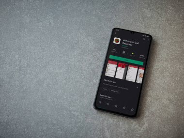 Lod, Israel - 8 Temmuz 2020: Seramik taş zemin üzerinde siyah bir cep telefonunun ekranında otomatik arama kaydedici uygulama oyun mağazası sayfası. Üst görünüm düzlüğü kopyalama alanı ile yatıyordu.