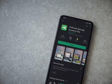 Lod, Israel - 8 Temmuz 2020: Airdroid uygulama oyun mağazası sayfası seramik taş zemin üzerinde siyah bir cep telefonu sergilenmektedir. Üst görünüm düzlüğü kopyalama alanı ile yatıyordu.