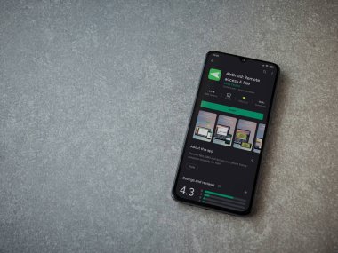 Lod, Israel - 8 Temmuz 2020: Airdroid uygulama oyun mağazası sayfası seramik taş zemin üzerinde siyah bir cep telefonu sergilenmektedir. Üst görünüm düzlüğü kopyalama alanı ile yatıyordu.