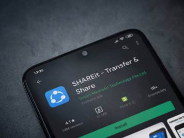 Lod, Israel - 8 Temmuz 2020: ShAREit uygulaması oyun mağazası sayfası koyu mermer taştan arka planda siyah bir cep telefonunun ekranında. Üst görünüm düzlüğü kopyalama alanı ile yatıyordu.