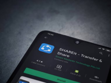 Lod, Israel - 8 Temmuz 2020: ShAREit uygulaması oyun mağazası sayfası koyu mermer taştan arka planda siyah bir cep telefonunun ekranında. Üst görünüm düzlüğü kopyalama alanı ile yatıyordu.