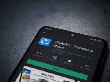 Lod, Israel - 8 Temmuz 2020: ShAREit uygulaması oyun mağazası sayfası koyu mermer taştan arka planda siyah bir cep telefonunun ekranında. Üst görünüm düzlüğü kopyalama alanı ile yatıyordu.
