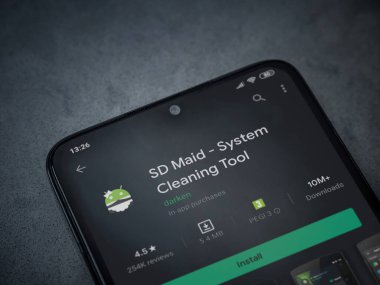 Lod, Israel - 8 Temmuz 2020: SD Maid uygulaması oyun mağazası sayfası koyu mermer taşlı arka planda siyah bir cep telefonu sergilenmektedir. Üst görünüm düzlüğü kopyalama alanı ile yatıyordu.