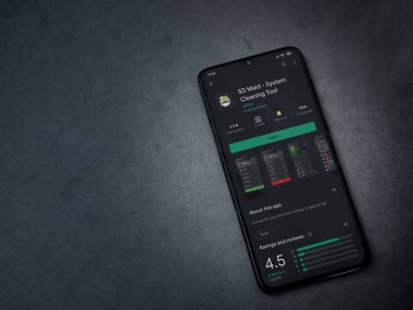 Lod, Israel - 8 Temmuz 2020: SD Maid uygulaması oyun mağazası sayfası koyu mermer taşlı arka planda siyah bir cep telefonu sergilenmektedir. Üst görünüm düzlüğü kopyalama alanı ile yatıyordu.