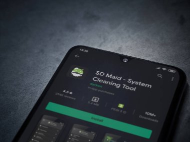 Lod, Israel - 8 Temmuz 2020: SD Maid uygulaması oyun mağazası sayfası koyu mermer taşlı arka planda siyah bir cep telefonu sergilenmektedir. Üst görünüm düzlüğü kopyalama alanı ile yatıyordu.