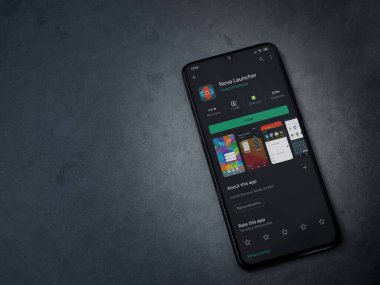 Lod, Israel - 8 Temmuz 2020: Nova Launcher uygulaması oyun mağazası sayfası koyu mermer taştan arka planda siyah bir cep telefonu görüntüsü. Üst görünüm düzlüğü kopyalama alanı ile yatıyordu.