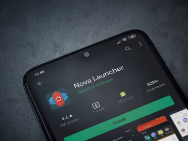 Lod, Israel - 8 Temmuz 2020: Nova Launcher uygulaması oyun mağazası sayfası koyu mermer taştan arka planda siyah bir cep telefonu görüntüsü. Üst görünüm düzlüğü kopyalama alanı ile yatıyordu.
