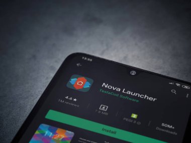 Lod, Israel - 8 Temmuz 2020: Nova Launcher uygulaması oyun mağazası sayfası koyu mermer taştan arka planda siyah bir cep telefonu görüntüsü. Üst görünüm düzlüğü kopyalama alanı ile yatıyordu.