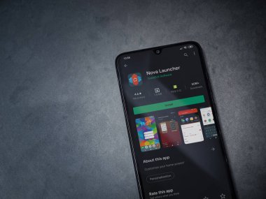Lod, Israel - 8 Temmuz 2020: Nova Launcher uygulaması oyun mağazası sayfası koyu mermer taştan arka planda siyah bir cep telefonu görüntüsü. Üst görünüm düzlüğü kopyalama alanı ile yatıyordu.