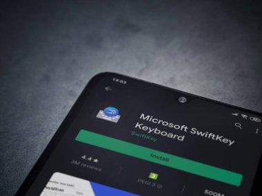 Lod, Israel - 8 Temmuz 2020: Microsoft SwiftKey Klavye uygulama oyun sayfası koyu mermer taşlı arka planda siyah bir cep telefonu sergilenmektedir. Üst görünüm düzlüğü kopyalama alanı ile yatıyordu.