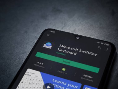 Lod, Israel - 8 Temmuz 2020: Microsoft SwiftKey Klavye uygulama oyun sayfası koyu mermer taşlı arka planda siyah bir cep telefonu sergilenmektedir. Üst görünüm düzlüğü kopyalama alanı ile yatıyordu.