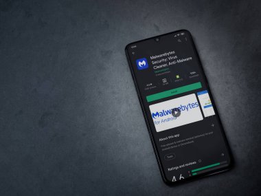 Lod, Israel - 8 Temmuz 2020: Malwarebytes Security uygulama oyun mağazası sayfası koyu mermer taşlı arka planda siyah bir cep telefonu sergilenmektedir. Üst görünüm düzlüğü kopyalama alanı ile yatıyordu.