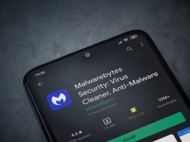 Lod, Israel - 8 Temmuz 2020: Malwarebytes Security uygulama oyun mağazası sayfası koyu mermer taşlı arka planda siyah bir cep telefonu sergilenmektedir. Üst görünüm düzlüğü kopyalama alanı ile yatıyordu.