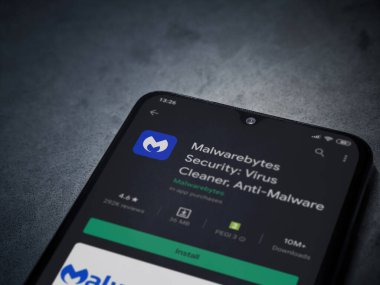 Lod, Israel - 8 Temmuz 2020: Malwarebytes Security uygulama oyun mağazası sayfası koyu mermer taşlı arka planda siyah bir cep telefonu sergilenmektedir. Üst görünüm düzlüğü kopyalama alanı ile yatıyordu.