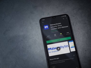 Lod, Israel - 8 Temmuz 2020: Malwarebytes Security uygulama oyun mağazası sayfası koyu mermer taşlı arka planda siyah bir cep telefonu sergilenmektedir. Üst görünüm düzlüğü kopyalama alanı ile yatıyordu.