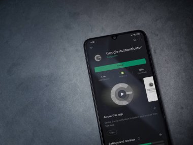 Lod, Israel - 8 Temmuz 2020: Google Authenticator uygulama oyun mağazası sayfası koyu mermer taştan arka planda siyah bir cep telefonu görüntüsü. Üst görünüm düzlüğü kopyalama alanı ile yatıyordu.