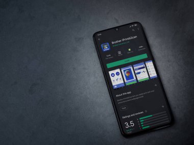 Lod, Israel - 8 Temmuz 2020: Kardeş iPrint & Scan uygulama oyun mağazası sayfası koyu mermer taşlı arka planda siyah bir cep telefonu görüntüsü. Üst görünüm düzlüğü kopyalama alanı ile yatıyordu.