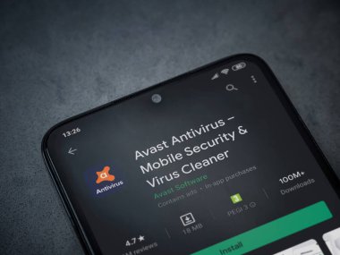 Lod, Israel - 8 Temmuz 2020: Antivirüs uygulaması oyun mağazası sayfasında koyu mermer taştan arka planda siyah bir cep telefonu görüntüsü. Üst görünüm düzlüğü kopyalama alanı ile yatıyordu.