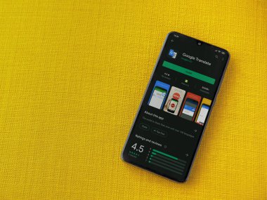 Lod, Israel - 8 Temmuz 2020: Google Applate playshop sayfası sarı kumaş arka planda siyah bir cep telefonu ekranında. Üst görünüm düzlüğü kopyalama alanı ile yatıyordu.