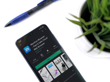 Lod, Israel - 8 Temmuz 2020: Maxthon Browser uygulamalı siyah cep telefonlu modern minimalist ofis çalışma alanı. Üst görünüm düzlüğü kopyalama alanı ile yatıyordu.