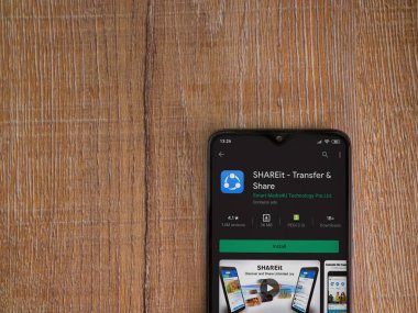 Lod, Israel - 8 Temmuz 2020: SharEit uygulaması oyun mağazası sayfası ahşap arka planda siyah bir cep telefonunun ekranında. Üst görünüm düzlüğü kopyalama alanı ile yatıyordu.