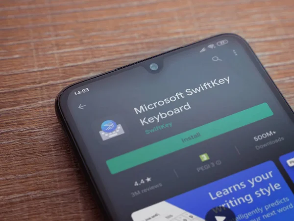 Lod, Israel - 8 Temmuz 2020: Microsoft SwiftKey Klavye uygulama oyun sayfası ahşap arka planda siyah bir cep telefonu ekranında. Üst görünüm düzlüğü kopyalama alanı ile yatıyordu.