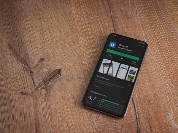 Lod, Israel - 8 Temmuz 2020: Microsoft Authenticator uygulama oyun mağazası sayfası ahşap arka planda siyah bir cep telefonu ekranında. Üst görünüm düzlüğü kopyalama alanı ile yatıyordu.
