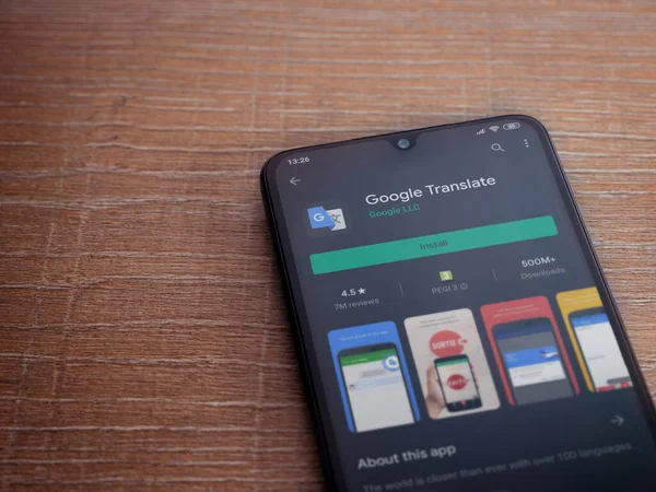 Lod, Israel - 8 Temmuz 2020: Google Translate uygulama oyun mağazası sayfası ahşap arka planda siyah bir cep telefonunun ekranında. Üst görünüm düzlüğü kopyalama alanı ile yatıyordu.