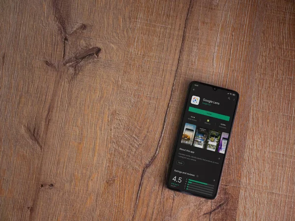 Lod, Israel - 8 Temmuz 2020: Google Lens uygulama oyun mağazası sayfası ahşap arka planda siyah bir cep telefonu ekranında. Üst görünüm düzlüğü kopyalama alanı ile yatıyordu.
