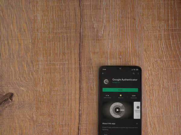 Lod, Israel - 8 Temmuz 2020: Google Authenticator uygulaması oyun mağazası sayfası ahşap arka planda siyah bir cep telefonu ekranında. Üst görünüm düzlüğü kopyalama alanı ile yatıyordu.