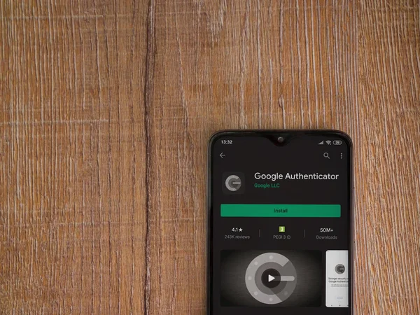 Lod, Israel - 8 Temmuz 2020: Google Authenticator uygulaması oyun mağazası sayfası ahşap arka planda siyah bir cep telefonu ekranında. Üst görünüm düzlüğü kopyalama alanı ile yatıyordu.