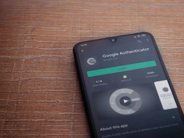 Lod, Israel - 8 Temmuz 2020: Google Authenticator uygulaması oyun mağazası sayfası ahşap arka planda siyah bir cep telefonu ekranında. Üst görünüm düzlüğü kopyalama alanı ile yatıyordu.