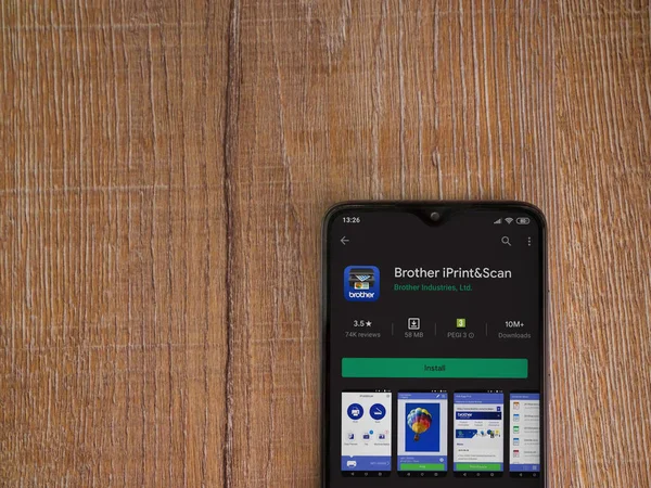 Lod, Israel - 8 Temmuz 2020: Kardeş iPrint & Scan uygulama oyun mağazası sayfası ahşap arka planda siyah bir cep telefonu görüntüsü. Üst görünüm düzlüğü kopyalama alanı ile yatıyordu.