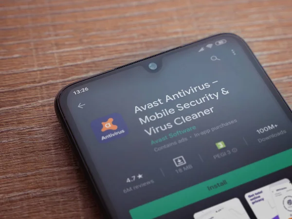 Lod, Israel - 8 Temmuz 2020: Antivirüs uygulaması oyun mağazası sayfasında ahşap arka planda siyah bir cep telefonu görüntüsü. Üst görünüm düzlüğü kopyalama alanı ile yatıyordu.
