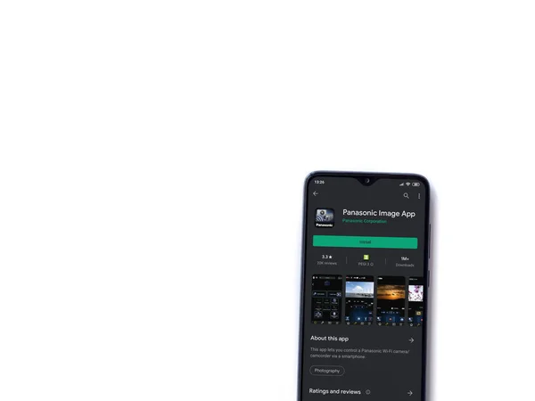 Lod Israel 2020年7月8日 白い背景に隔離された黒いモバイルスマートフォンのディスプレイ上のパナソニックイメージアプリのプレイストアページ コピースペース付きのトップビューフラットレイ — ストック写真