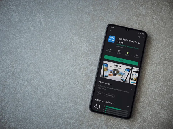 Lod, Israel - 8 Temmuz 2020: Seramik taş zemin üzerinde siyah bir cep telefonunun sergilendiği SHAREit uygulaması oyun mağazası sayfası. Üst görünüm düzlüğü kopyalama alanı ile yatıyordu.