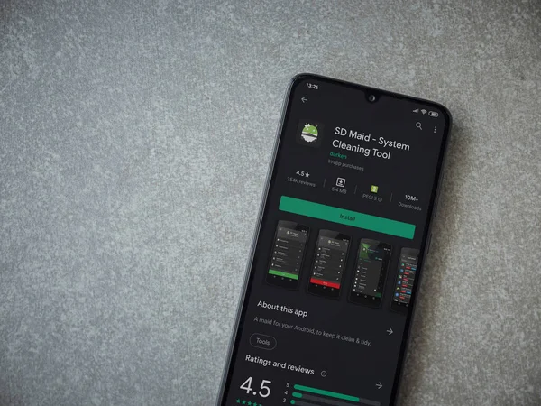Lod, Israel - 8 Temmuz 2020: SD Maid uygulaması oyun mağazası sayfası seramik taş zemin üzerinde siyah bir cep telefonu görüntüsü. Üst görünüm düzlüğü kopyalama alanı ile yatıyordu.