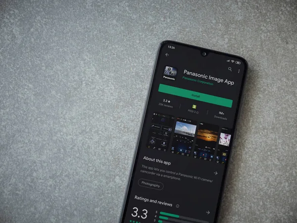 Lod, Israel - 8 Temmuz 2020: Panasonic Image App uygulama oyun mağazası sayfası seramik taş zemin üzerinde siyah bir cep telefonu görüntüsü. Üst görünüm düzlüğü kopyalama alanı ile yatıyordu.